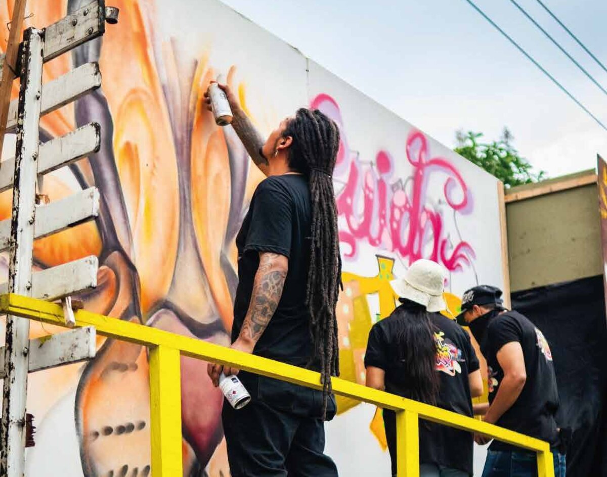 Artist spray-painting a mural on Avenida del Arte, Pereira. Photo: Colectivo Transformadores On Going.
