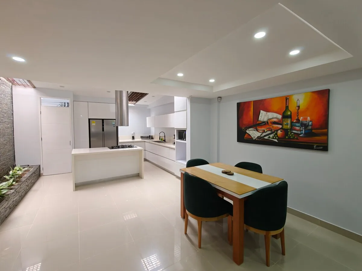 Open-plan white kitchen with island and dining area