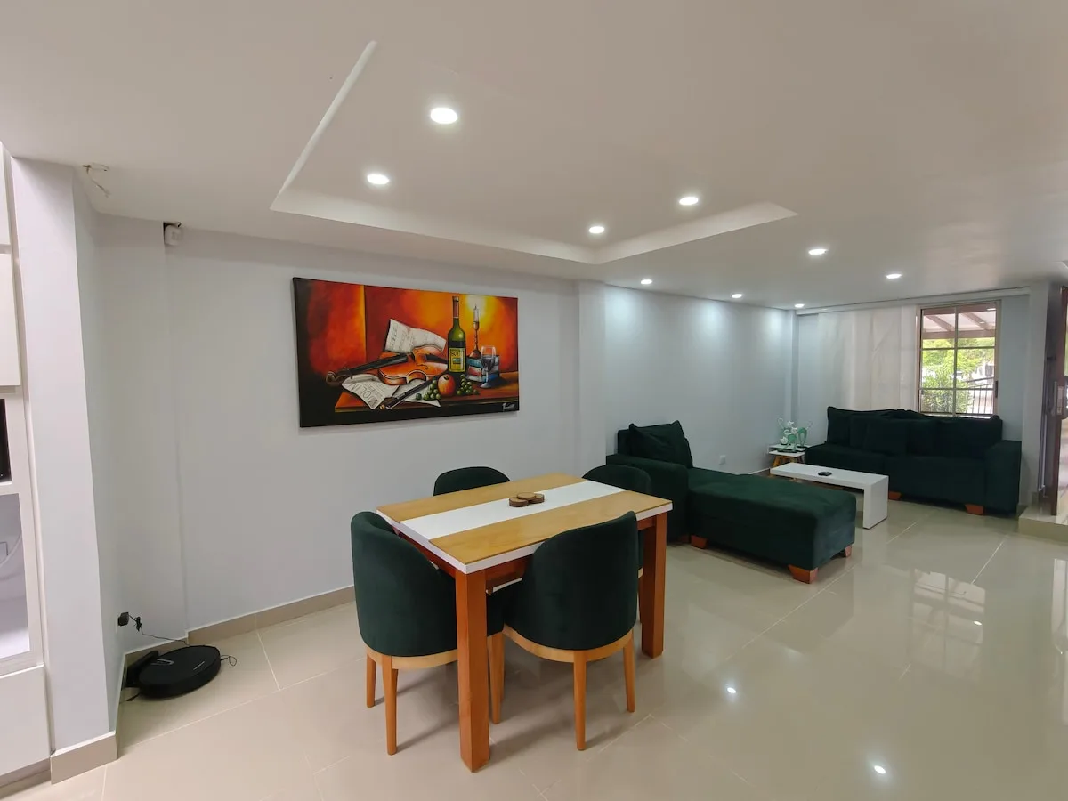 Bright living room with green sofa and tile floors